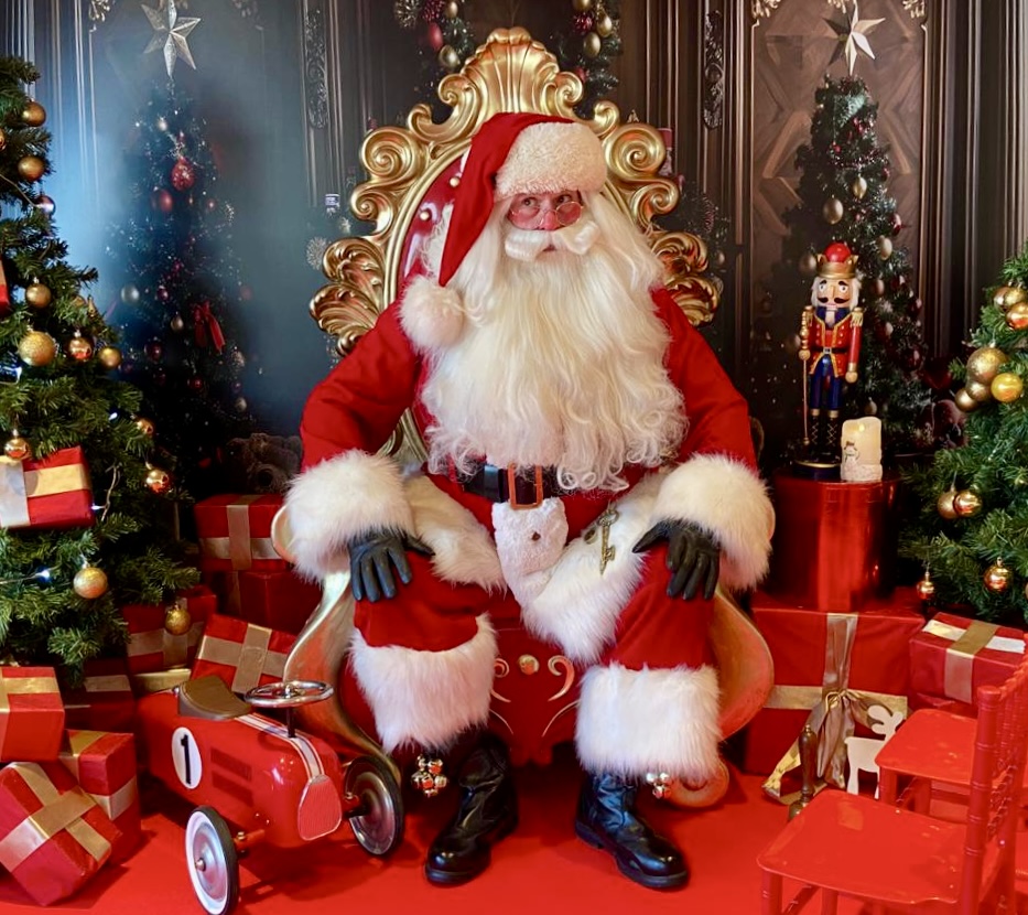 Santa sitting on a throne at a grotto.